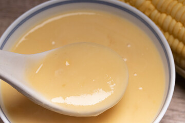 Sweet corn soup in a ceramic cup on wooden background.copy space