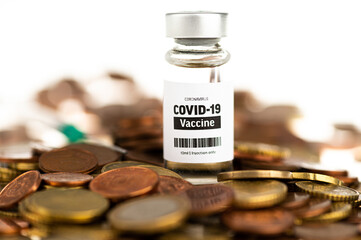 Vial glass bottle of COVID-19 vaccine standing on euro coins. SARS - CoV2 vaccination concept. Vaccine against coronavirus. Money behind a vaccine procurement. 