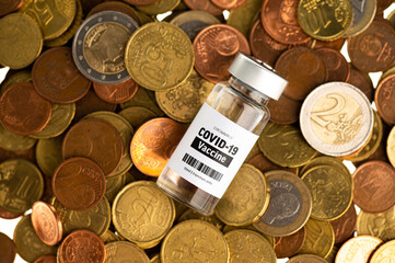 Vial glass bottle of COVID-19 vaccine standing on euro coins. SARS - CoV2 vaccination concept. Vaccine against coronavirus. Money behind a vaccine procurement. 