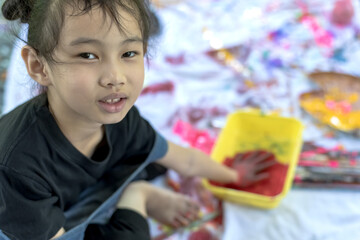 Fototapeta na wymiar Little asian artist girl having fun playing with colored painting tray in art school, Kids Artist