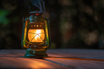 Fototapeta na wymiar antique kerosene lamp with lights on the wooden floor at night