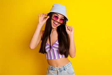 Photo of adorable funky girl dressed swimsuit bra cap making hair fake mustaches isolated yellow color background