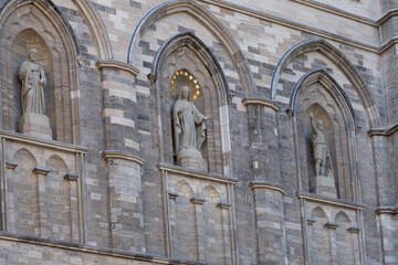 Detail of 1830 catholic Notre-Dame Basilica with Saint-Joseph, the Virgin Mary, and Saint Jean-Baptiste statues in stone facade niches, Montreal, Quebec, Canada - obrazy, fototapety, plakaty