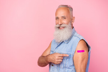 Photo of cool confident man pensioner dressed denim vest pointing sticky plaster empty space isolated pink color background