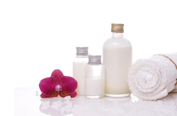  Spa setting with bottles of essential oil , candle , rolled towel, orchid 
