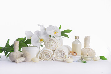Fototapeta na wymiar Spa setting with bottles of essential oil , , herbal ,ball, candle , three rolled towel, candle,, leaves ,orchid