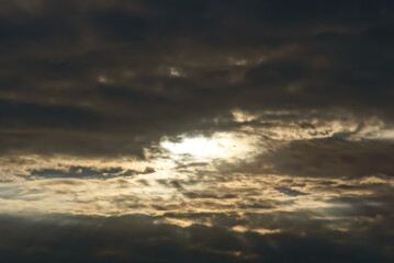 Obraz premium gray and black clouds in the evening sky with sun rays