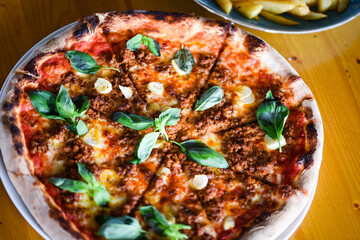 tasty bolognese pizza with fresh basil