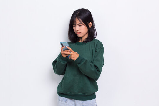 mad and shock young asian beautiful woman using mobile phone isolated on white background
