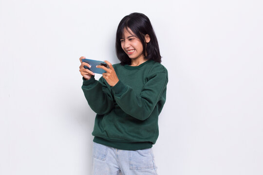 mad and shock young asian beautiful woman using mobile phone isolated on white background
