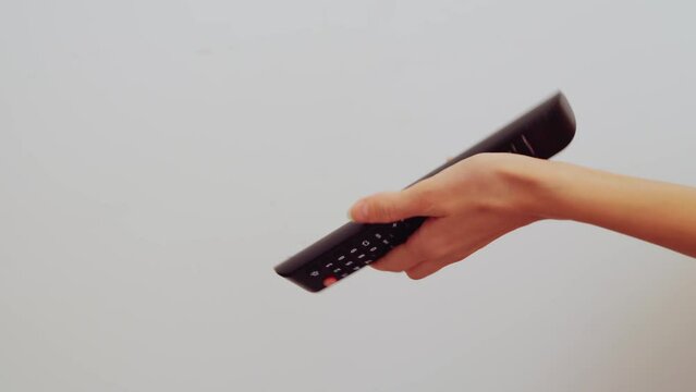 close-up women's hands try to turn on the TV, but they can't do it and they hit it because the remote switch doesn't work