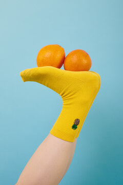 creative yellow socks with the image of a pineapple on a blue background with orange oranges on the foot