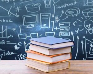 A pile of books with mathematical equations and graphs in the screen against a dark background