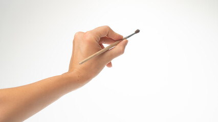 Drawing brush in a woman's left hand, gesture draws left-handed