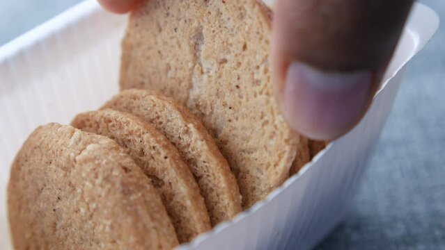 close up of hand pick a sweet cookie from a plastic container 
