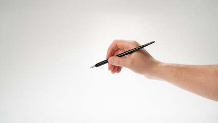 The right hand of a man holds a pen for calligraphy and writing, gesture writes