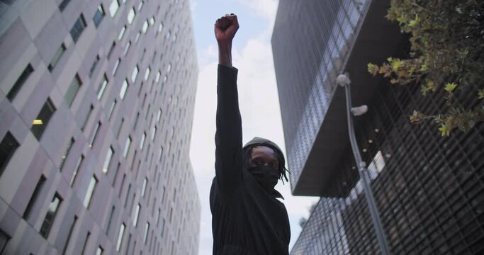 Confident Black African American man protests against discrimination standing looking at camera showing with hand gestures fist against racism racial discrimination solidarity. High quality 4k footage