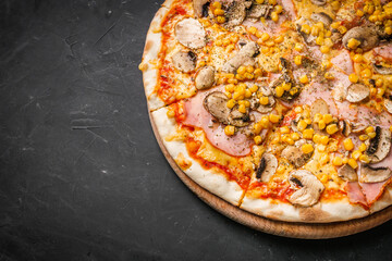 hot delicious traditional italian pizza on a dark stone background