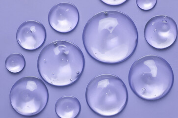 Cosmetic serum gel beauty drop on blue color background. Skincare beauty product with bubbles texture.	