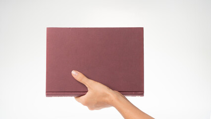 Obraz premium A woman's hand holds the book vertically space for the inscription