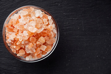 pink Himalayan salt on a black wooden rustic background
