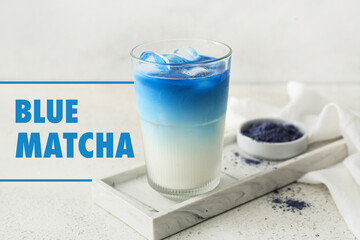 Glass of blue matcha tea on light background