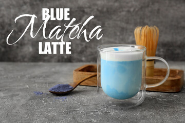 Glass cup of blue matcha latte on grey background