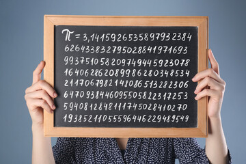 Woman holding chalkboard with number Pi on grey background - obrazy, fototapety, plakaty