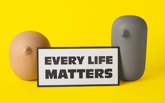 Figurines of birds and paper sheet with text EVERY LIFE MATTERS on color background