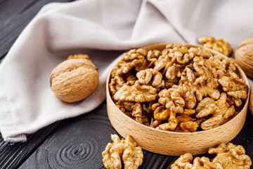dried walnuts on a black rustic wooden background