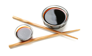 Bowls of soy sauce and chopsticks on white background