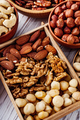set of different nuts on a white wooden rustic background