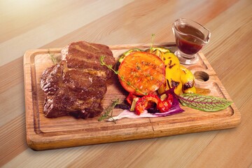 Slices of grilled steak pork on a wooden cutting board. Food concept