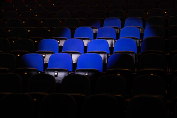 Close up shot of interior of cinema auditorium with lines of blue chairs. Horizontal shot