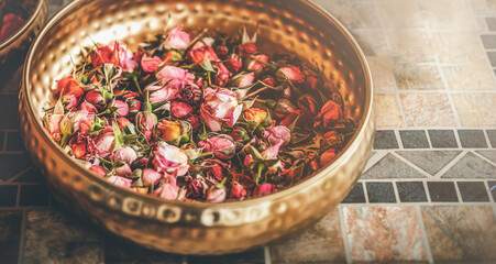 Rose flower in a brass bowl. Spa and aromatherapy.