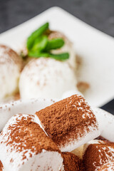 hot chocolate with marshmallows and ice cream balls on a black background