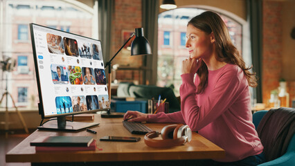 Young Beautiful Woman Watching Videos on Online Streaming Service. Creative Female Checking Social Media, Browsing Internet, Consuming Content From Influencers. Urban City View from Big Window.