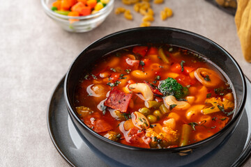 Minestrone Soup is a thick soup of Italian origin made with vegetables, often with the addition of pasta or rice.