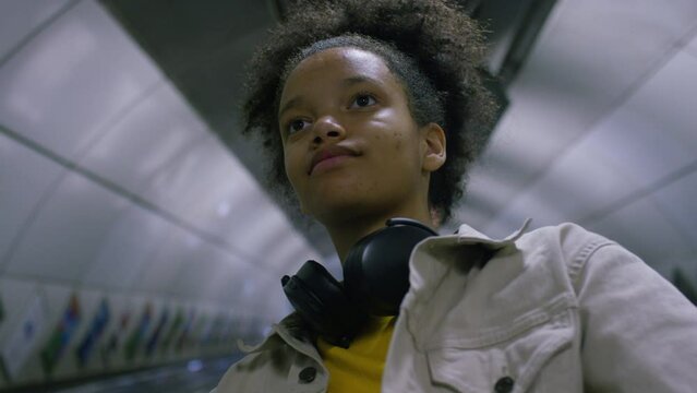 Portrait of teenager commuting on a moving escalator