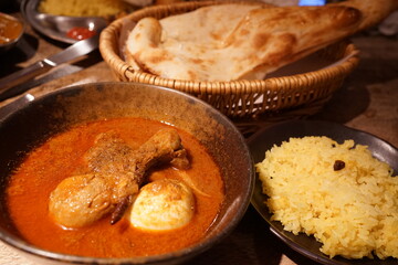 Assorted Indian curry in a copper brass serving oriental bowl, pieces of chicken fillet, close-up - インド料理 チキン カレー ナン