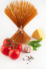 On a white background, tomatoes, garlic, basil, peppers, spaghetti, cheese. The concept of cooking.