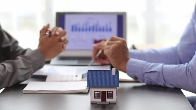 Businessmen discuss real estate project ideas and plan budget allocations to maximize profits. Real estate agents who are talking about homes are offering customers the prices of housing projects.