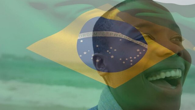 Animation of flag of brazil over african american woman at beach