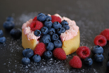Cake with cream covered with juicy berries.