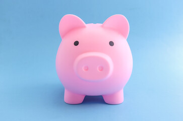 pink piggy bank on blue paper background