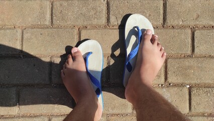 Abstract Defocused Background A pair of feet stepping on white and blue sandals in the afternoon in...