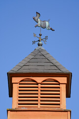 Tower of pig barn with pig sculpture decorated weather vane
