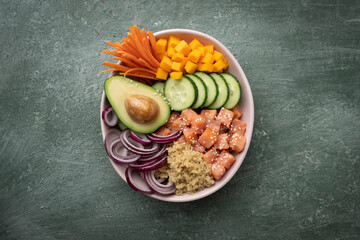 Poke bowl with quinoa and salmon and raw vegetables, healthy food bowl, top view