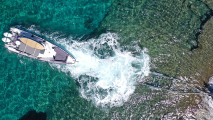 Fototapeta premium Aerial top view photo of speed boat on transport trailer being towed by truck from emerald sea shore to land