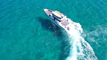 Naklejka premium Aerial drone photo of small speed boat with dual outboards cruising in high speed deep blue Aegean sea